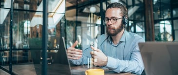 An individual using virtual conference technology to communicate with colleagues and peers.